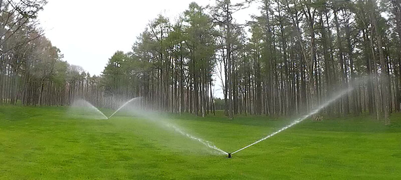 散水機器によりゴルフ場で水を噴射している様子